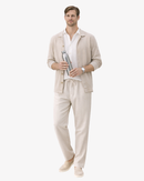 Man in beige lounge set and white shirt holding metal bottle, Arlori fashion clothing