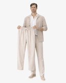 Man in beige linen outfit holding matching drawstring pants, Arlori collection